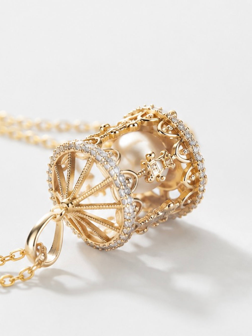 Luxe Carousel Pearl Pendant Necklace featuring a luminous pearl suspended inside an intricately detailed carousel pendant with sparkling accents and a gold-tone finish on a 40 + 5 cm chain.
