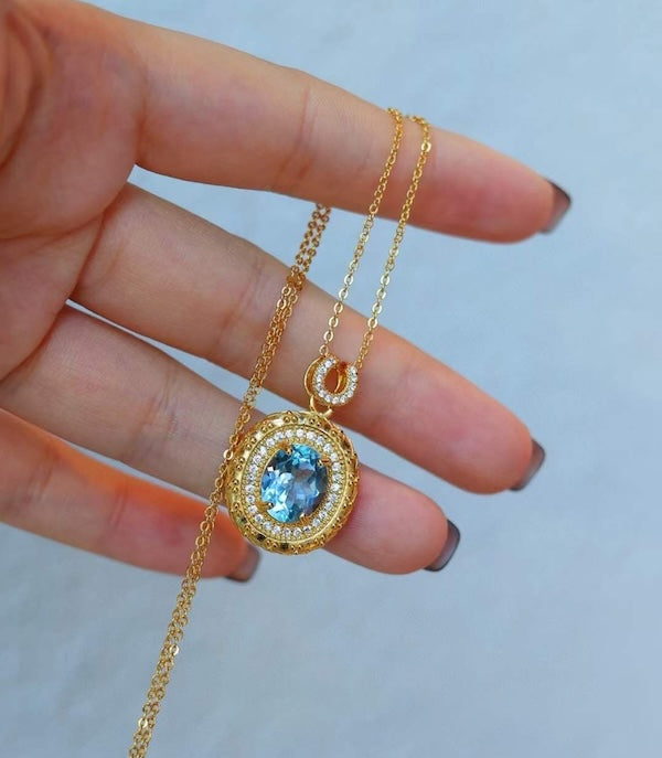 Heirloom Blue Topaz Pendant Necklace featuring an oval genuine blue topaz gemstone surrounded by ornate gold vermeil detailing and delicate sparkling accents.