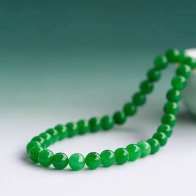 Imperial Jade Bead Necklace featuring genuine vivid green jade beads arranged in a classic strand necklace with a polished, elegant appearance.