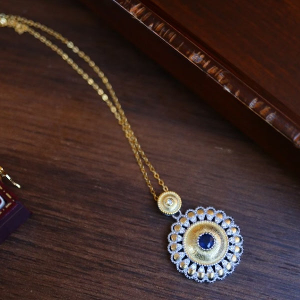 Sapphire Soleil Pendant Necklace featuring a genuine blue sapphire gemstone at the center of an ornate gold vermeil sunburst-inspired pendant with delicate openwork details.