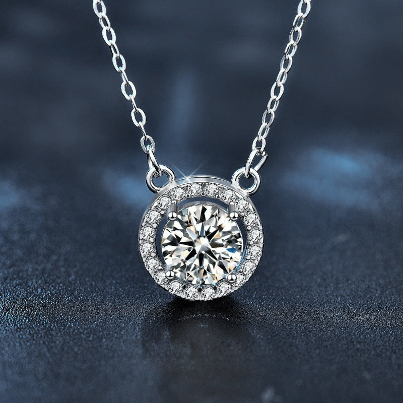 Sparkling Moissanite Halo Necklace featuring a round brilliant moissanite surrounded by a halo of accent stones in a sterling silver setting.
