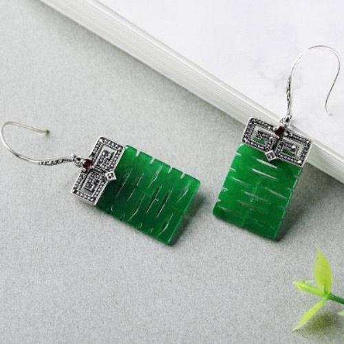 Double Happiness Jade Drop Earrings featuring vibrant green jade panels suspended beneath ornate Chinese-inspired sterling silver details with symbolic Double Happiness motifs.
