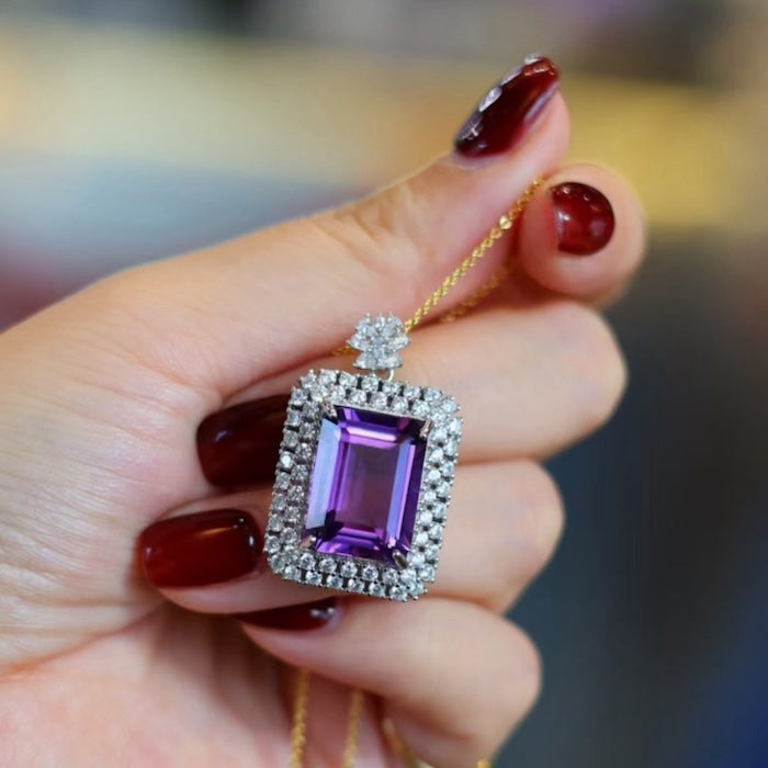 Regal Amethyst Halo Pendant featuring a large emerald-cut genuine amethyst gemstone surrounded by a halo of sparkling accents in an elegant sterling silver setting.