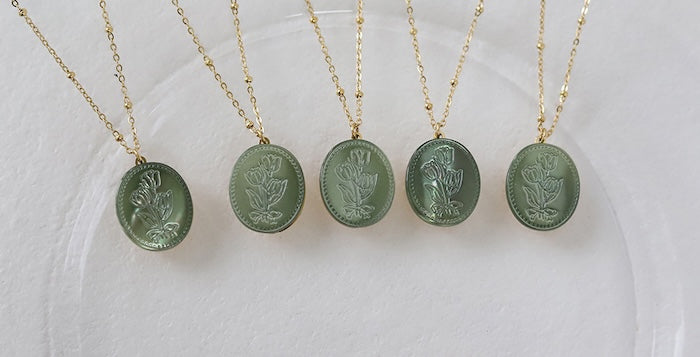 Vintage Botanical Mother of Pearl Medallion Necklace with an engraved floral pendant in powder blue, sage green, or lavender on a gold-plated stainless steel chain.