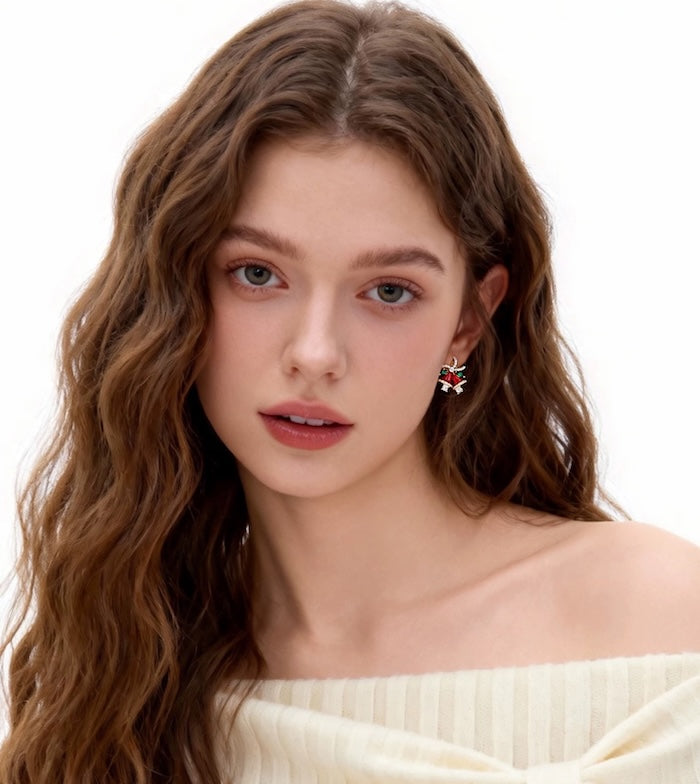Festive Red Christmas Bell Earrings featuring red bell charms, simulated pearl bows, green leaf accents, and gold-plated brass.