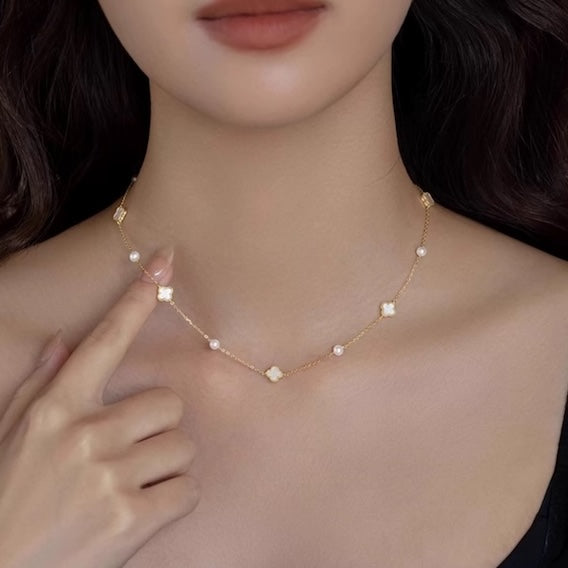 Petite Clover & Pearl Charm Necklace with white clover motifs and freshwater pearl accents, available in gold and silver.