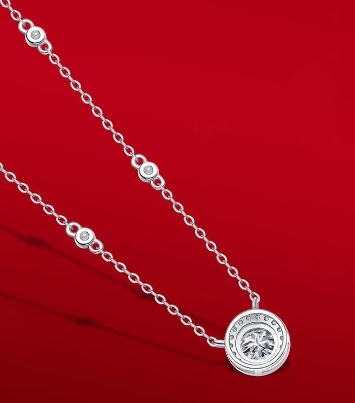 Star Halo Moissanite Necklace featuring a 1 ct round moissanite center stone surrounded by a sparkling halo, accented with bezel-set moissanite stones along a sterling silver chain.