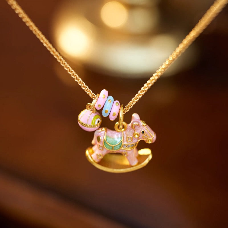 Enchanted Enamel Rocking Horse Charm Necklace with pastel rocking horse and miniature charms on a gold-plated chain.