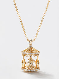 Luxe Carousel Pearl Pendant Necklace featuring a luminous pearl suspended inside an intricately detailed carousel pendant with sparkling accents and a gold-tone finish on a 40 + 5 cm chain.