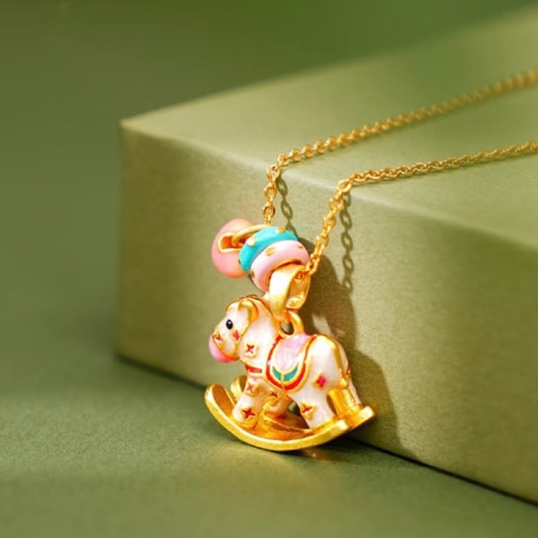 Enchanted Enamel Rocking Horse Charm Necklace with pastel rocking horse and miniature charms on a gold-plated chain.