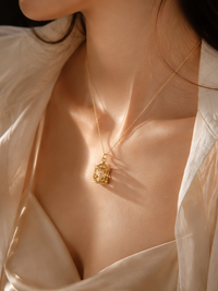 Luxe Carousel Pearl Pendant Necklace featuring a luminous pearl suspended inside an intricately detailed carousel pendant with sparkling accents and a gold-tone finish on a 40 + 5 cm chain.