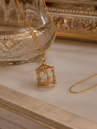 Luxe Carousel Pearl Pendant Necklace featuring a luminous pearl suspended inside an intricately detailed carousel pendant with sparkling accents and a gold-tone finish on a 40 + 5 cm chain.