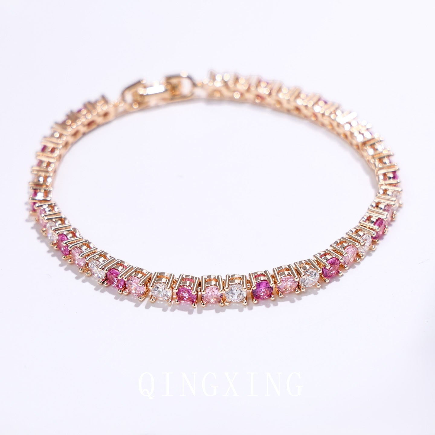 Dazzling Pink Ombré Tennis Bracelet featuring sparkling pink and clear zirconias in a gradient tennis bracelet design, available in two stone sizes.