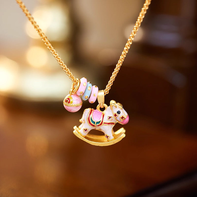 Enchanted Enamel Rocking Horse Charm Necklace with pastel rocking horse and miniature charms on a gold-plated chain.