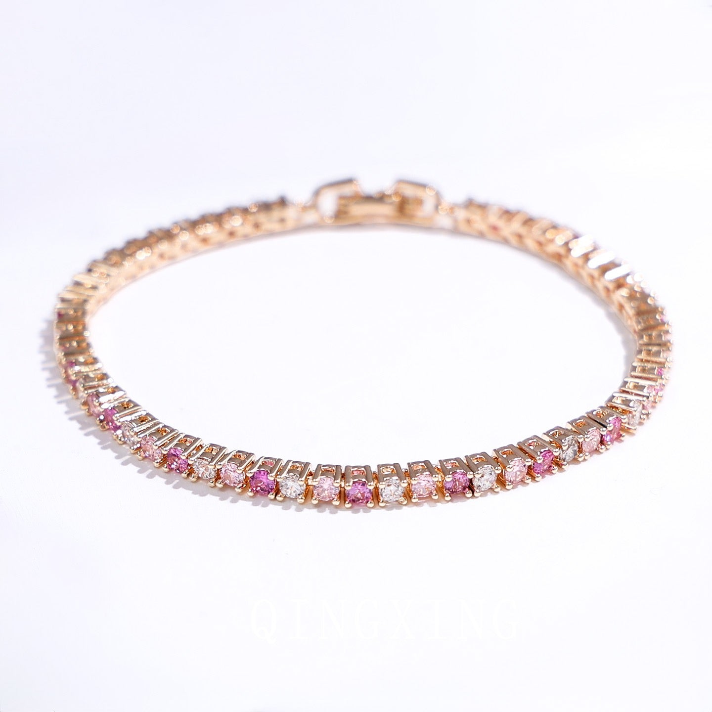 Dazzling Pink Ombré Tennis Bracelet featuring sparkling pink and clear zirconias in a gradient tennis bracelet design, available in two stone sizes.