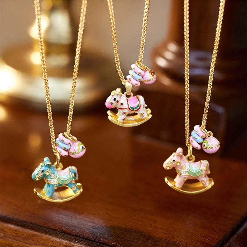 Enchanted Enamel Rocking Horse Charm Necklace with pastel rocking horse and miniature charms on a gold-plated chain.