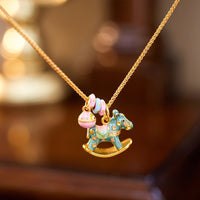 Enchanted Enamel Rocking Horse Charm Necklace with pastel rocking horse and miniature charms on a gold-plated chain.