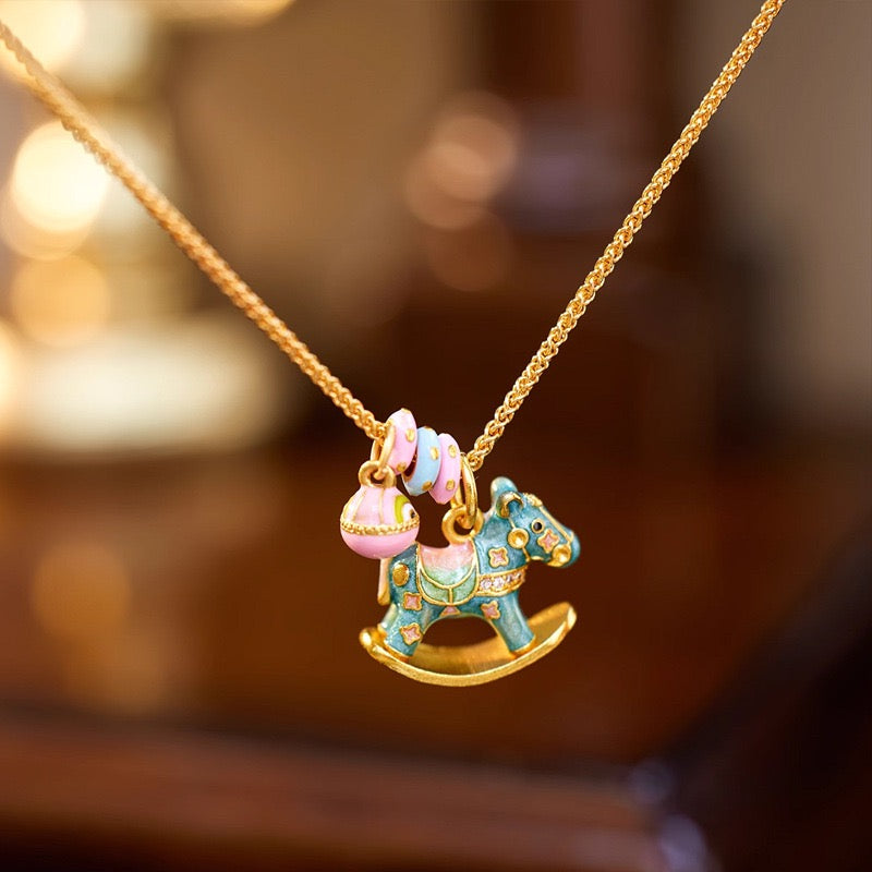 Enchanted Enamel Rocking Horse Charm Necklace with pastel rocking horse and miniature charms on a gold-plated chain.