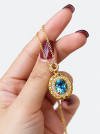 Heirloom Blue Topaz Pendant Necklace featuring an oval genuine blue topaz gemstone surrounded by ornate gold vermeil detailing and delicate sparkling accents.