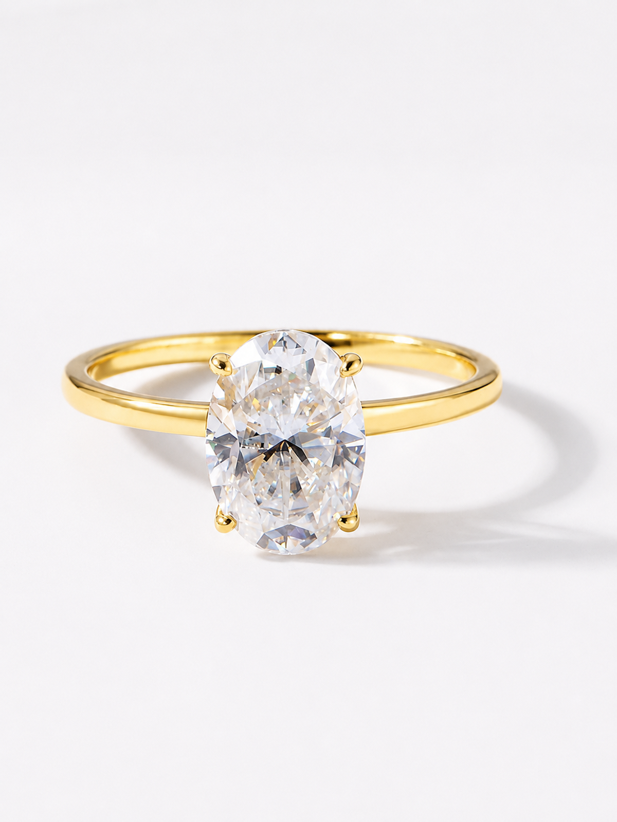 Éclat oval moissanite solitaire ring with VVS1 stone, four-prong setting and slender 14K gold-plated sterling silver band.