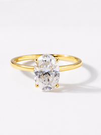 Éclat oval moissanite solitaire ring with VVS1 stone, four-prong setting and slender 14K gold-plated sterling silver band.