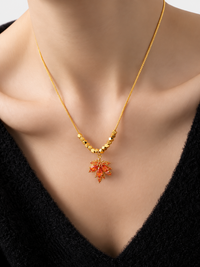 Fiery Orange Crystal Maple Leaf Necklace with orange crystal leaf pendant, faceted golden beads and delicate gold-plated chain.