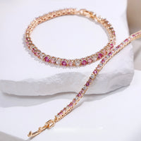 Dazzling Pink Ombré Tennis Bracelet featuring sparkling pink and clear zirconias in a gradient tennis bracelet design, available in two stone sizes.