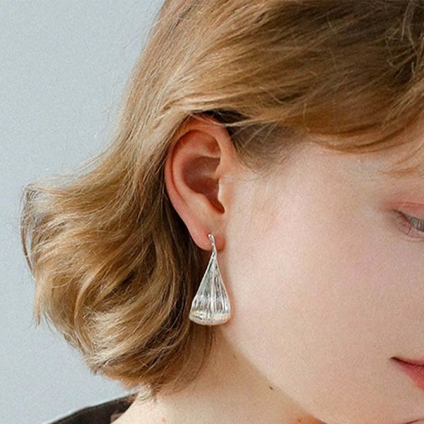 Elongated Curved Leaf Drop Earrings in silver plating with a flowing leaf-inspired silhouette and polished finish.