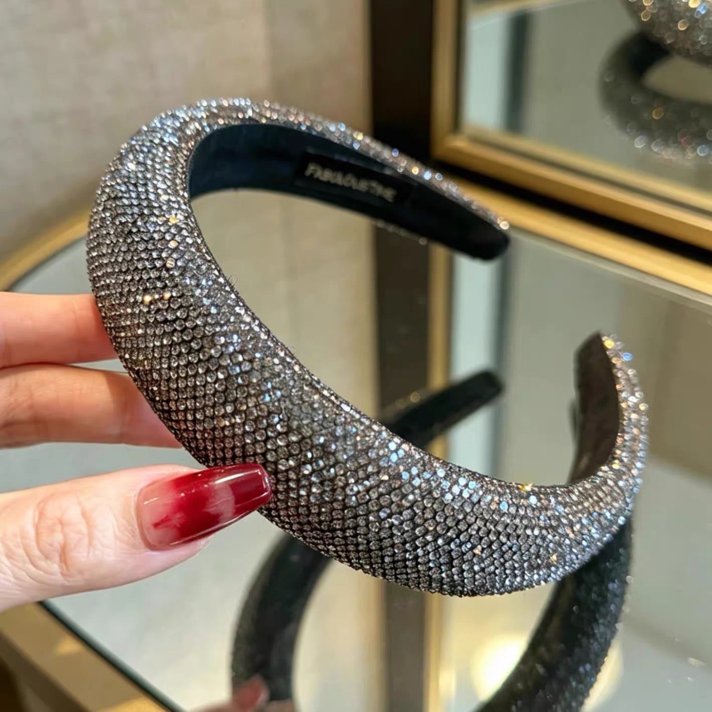 Dark silver pavé crystal padded headband with all-over sparkling embellishments and a sculptural curved silhouette.