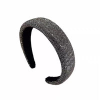 Dark silver pavé crystal padded headband with all-over sparkling embellishments and a sculptural curved silhouette.