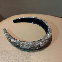  Dark silver pavé crystal padded headband with all-over sparkling embellishments and a sculptural curved silhouette.