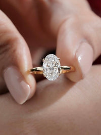 Éclat oval moissanite solitaire ring with VVS1 stone, four-prong setting and slender 14K gold-plated sterling silver band.