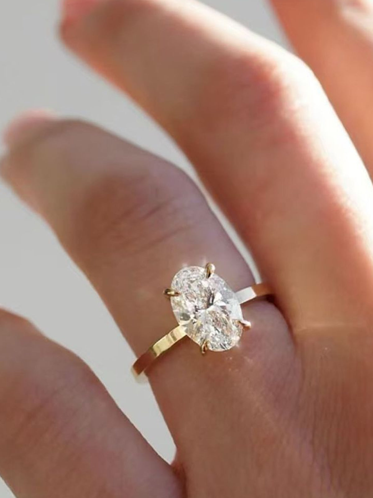 Éclat oval moissanite solitaire ring with VVS1 stone, four-prong setting and slender 14K gold-plated sterling silver band.
