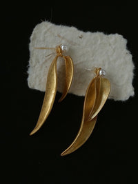 Golden cascading leaf earrings with layered curved leaves and white pearl studs.