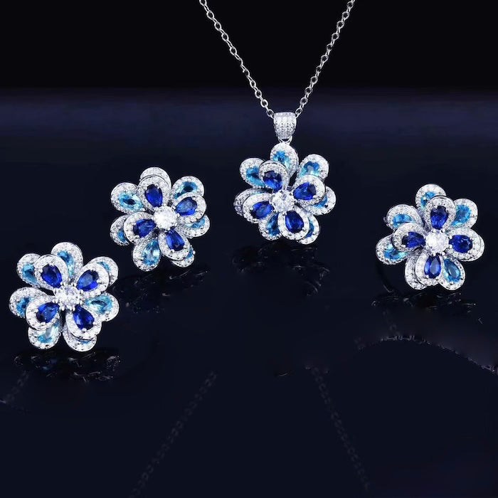 Azure Oil Painting Floral Jewelry Set featuring sapphire-blue and aqua crystal flowers with sparkling premium-grade zirconia in a matching pendant necklace, stud earrings, and adjustable ring.