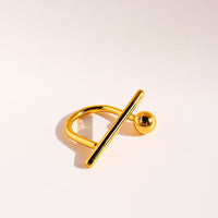 Sculptural Beam and Dot Ring featuring a contemporary geometric design with a polished bar and sphere detail, available in gold and silver-tone finishes.
