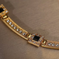 Vintage Style Geometric Black Onyx Jewelry Set featuring geometric black stones and sparkling zirconia accents in a gold-tone necklace and matching earrings.
