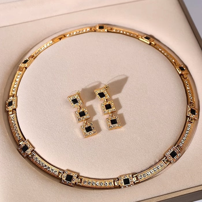 Vintage Style Geometric Black Onyx Jewelry Set featuring geometric black stones and sparkling zirconia accents in a gold-tone necklace and matching earrings.
