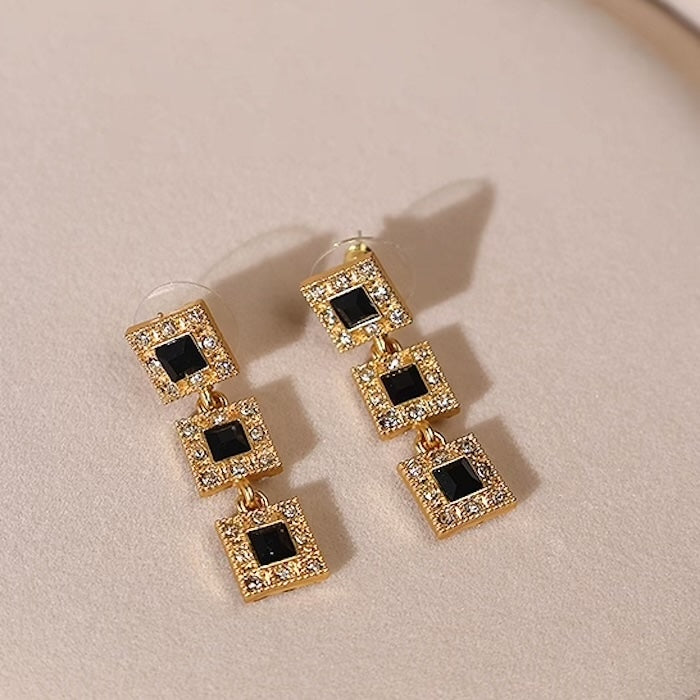 Vintage Style Geometric Black Onyx Jewelry Set featuring geometric black stones and sparkling zirconia accents in a gold-tone necklace and matching earrings.
