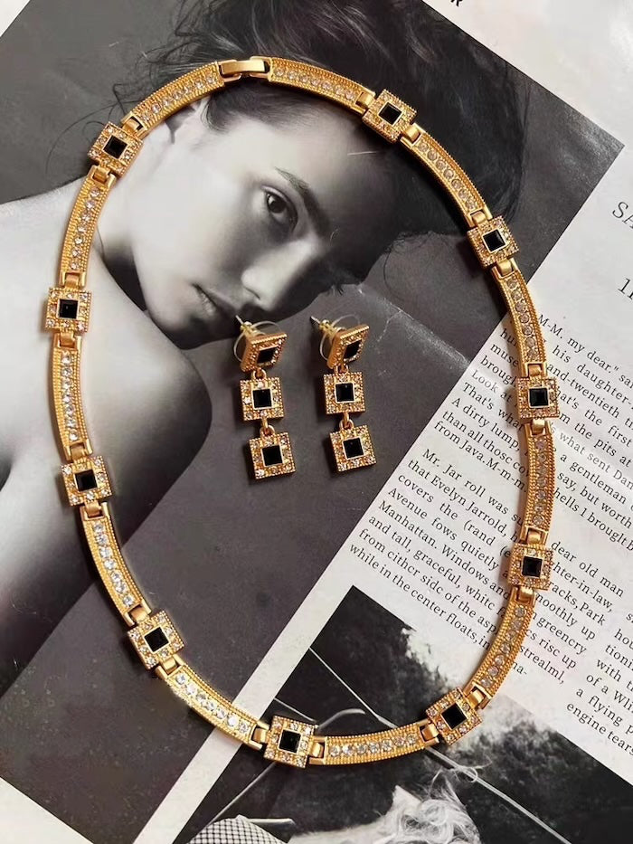 Vintage Style Geometric Black Onyx Jewelry Set featuring geometric black stones and sparkling zirconia accents in a gold-tone necklace and matching earrings.
