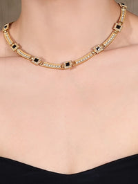 Vintage Style Geometric Black Onyx Jewelry Set featuring geometric black stones and sparkling zirconia accents in a gold-tone necklace and matching earrings.
