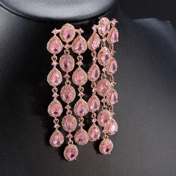 Blush Diamond Couture Jewelry Set featuring an open rose gold-plated cuff bangle, matching tennis bracelet, and cascading chandelier earrings adorned with brilliant blush pink stones.