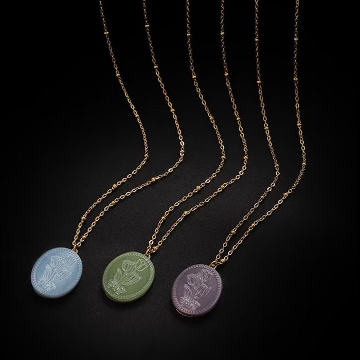 Vintage Botanical Mother of Pearl Medallion Necklace with an engraved floral pendant in powder blue, sage green, or lavender on a gold-plated stainless steel chain.
