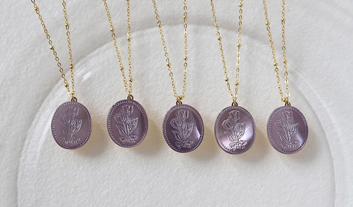 Vintage Botanical Mother of Pearl Medallion Necklace with an engraved floral pendant in powder blue, sage green, or lavender on a gold-plated stainless steel chain.
