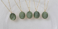 Vintage Botanical Mother of Pearl Medallion Necklace with an engraved floral pendant in powder blue, sage green, or lavender on a gold-plated stainless steel chain.
