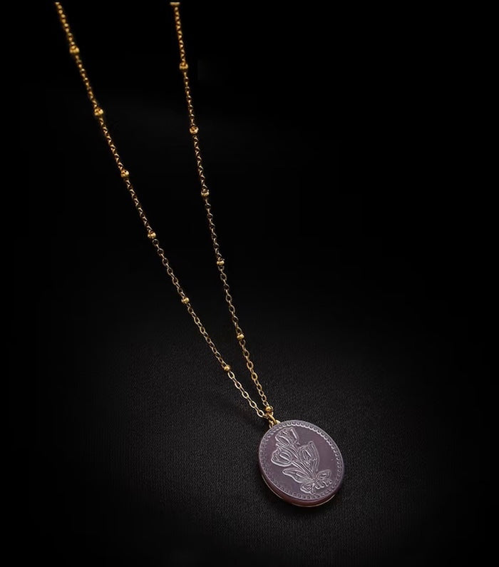 Vintage Botanical Mother of Pearl Medallion Necklace with an engraved floral pendant in powder blue, sage green, or lavender on a gold-plated stainless steel chain.
