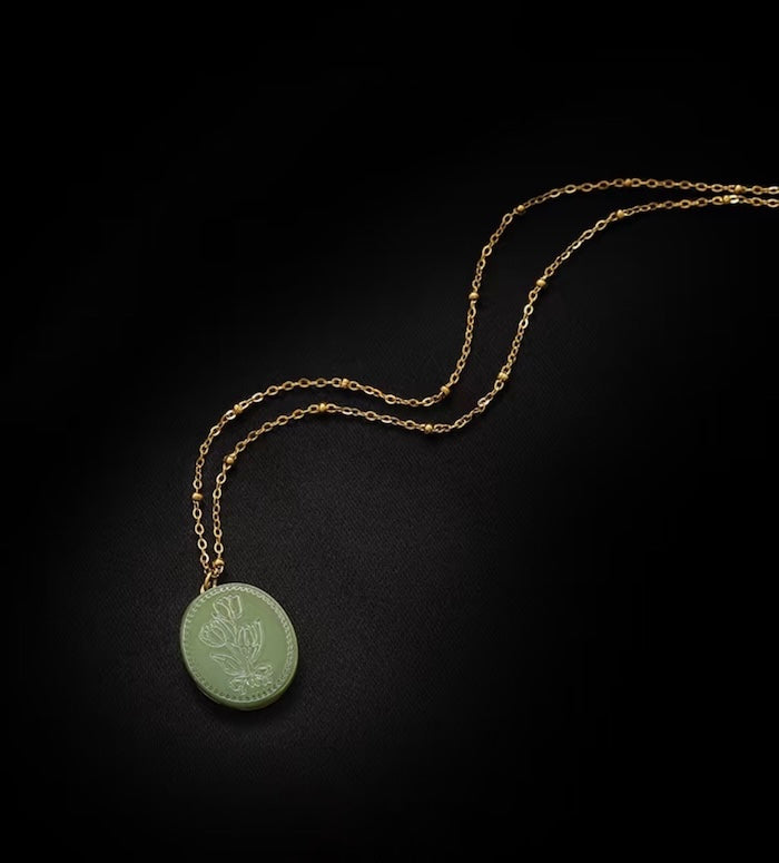 Vintage Botanical Mother of Pearl Medallion Necklace with an engraved floral pendant in powder blue, sage green, or lavender on a gold-plated stainless steel chain.
