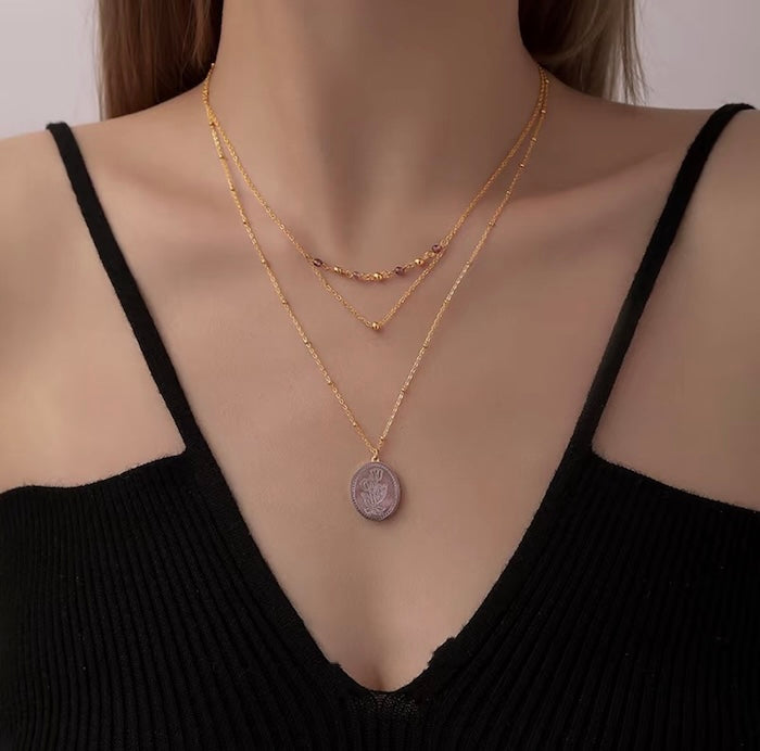 Vintage Botanical Mother of Pearl Medallion Necklace with an engraved floral pendant in powder blue, sage green, or lavender on a gold-plated stainless steel chain.
