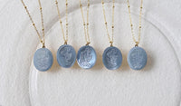 Vintage Botanical Mother of Pearl Medallion Necklace with an engraved floral pendant in powder blue, sage green, or lavender on a gold-plated stainless steel chain.
