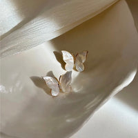 Iridescent Butterfly Shell Stud Earrings featuring luminous shell wings and delicate zirconia accents in a butterfly-inspired gold-tone design.
